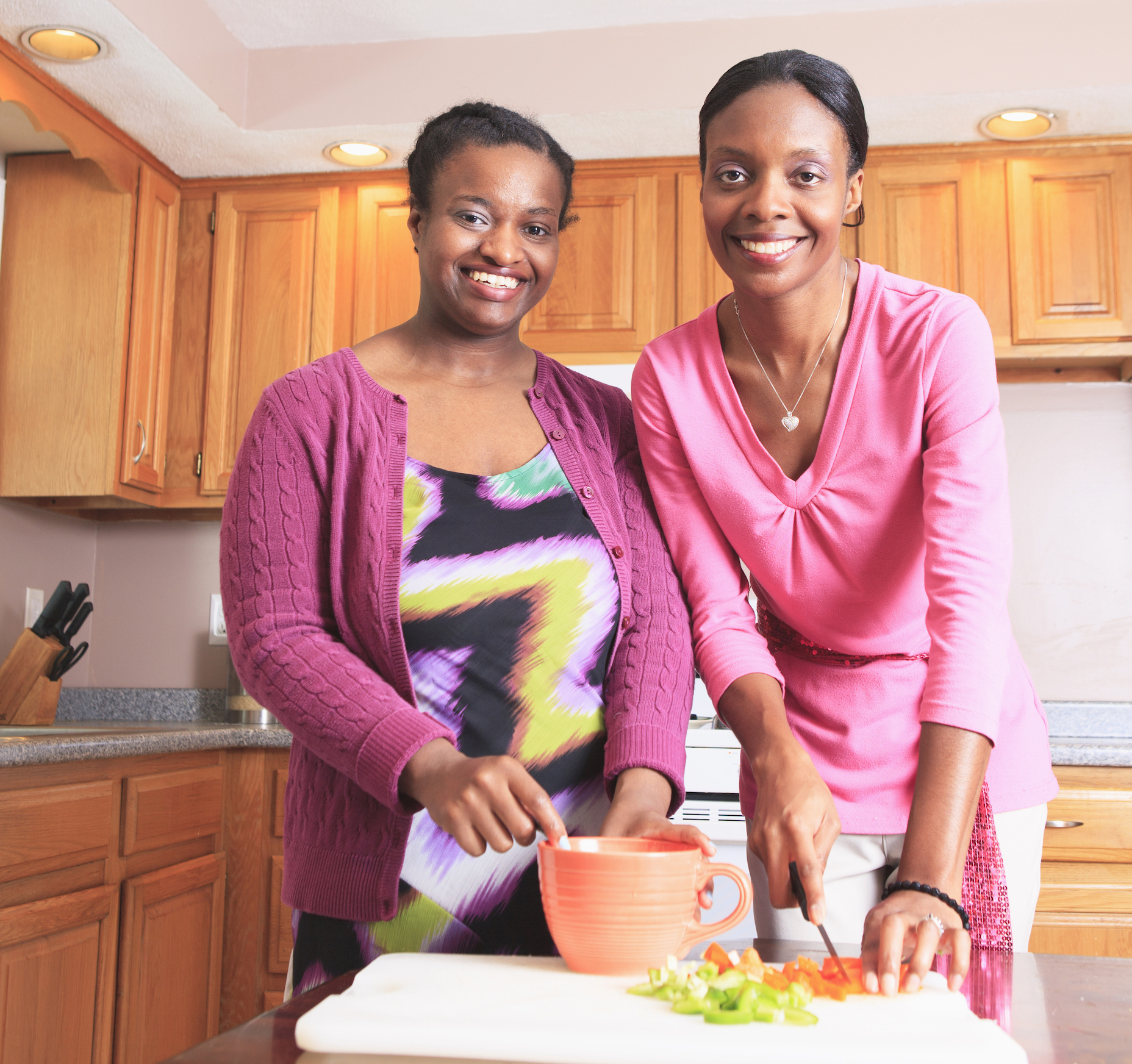 Two women cooking with each other. 